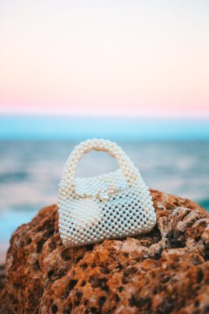 49245340 pearl bag on the beach a sunset
