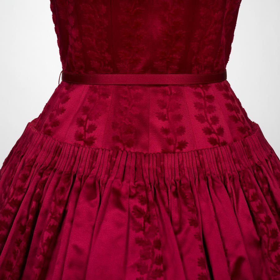 Falda plisada de un vestido de seda roja con dibujo de hojas en terciopelo cortado y cinta en la cintura